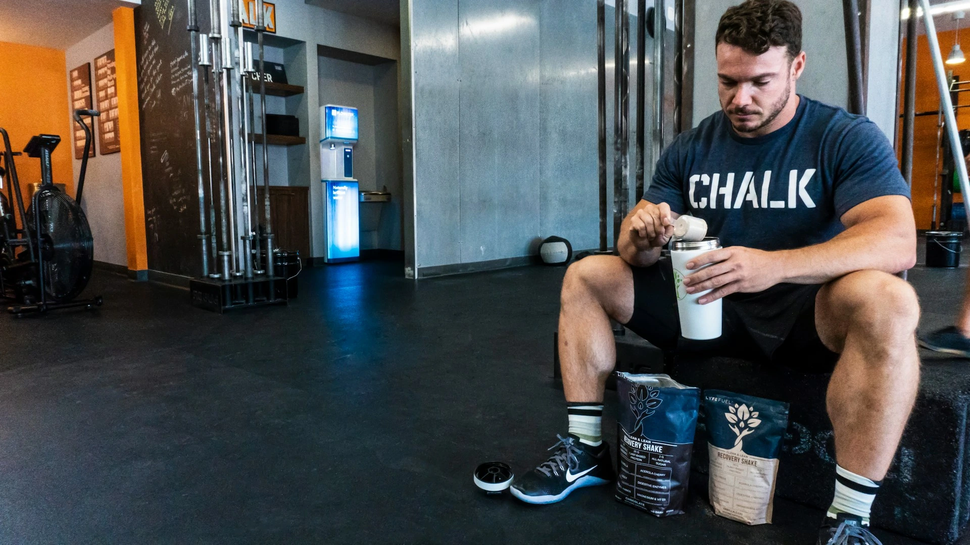 Protein tozuyla içecek karışımı hazırlayan bir sporcu. Protein tozuyla içecek karışımı hazırlayan bir sporcu.